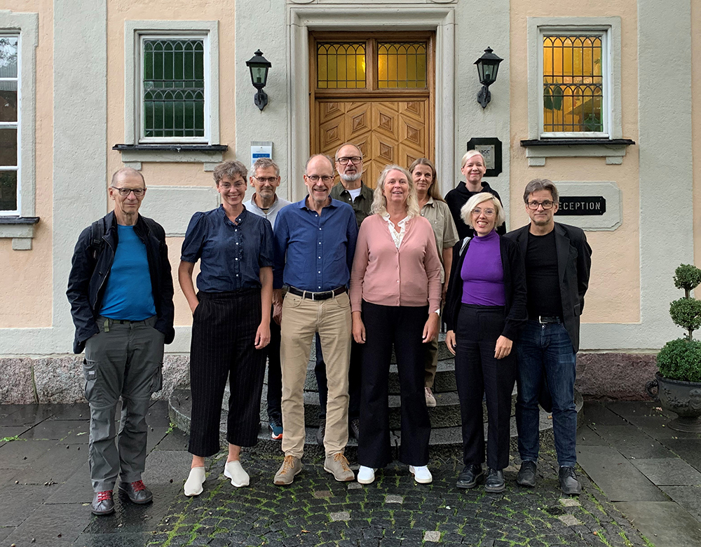 The management group stands in front of a building